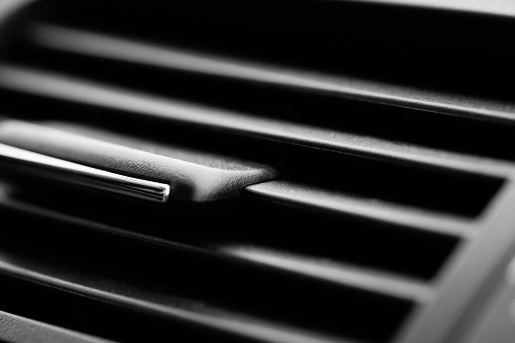 Full frame car interior ventilation detail close-up. Automobile still life closeup detail with selective focus. Vehicle air conditioner still life background, modern car interior and transportation concept.