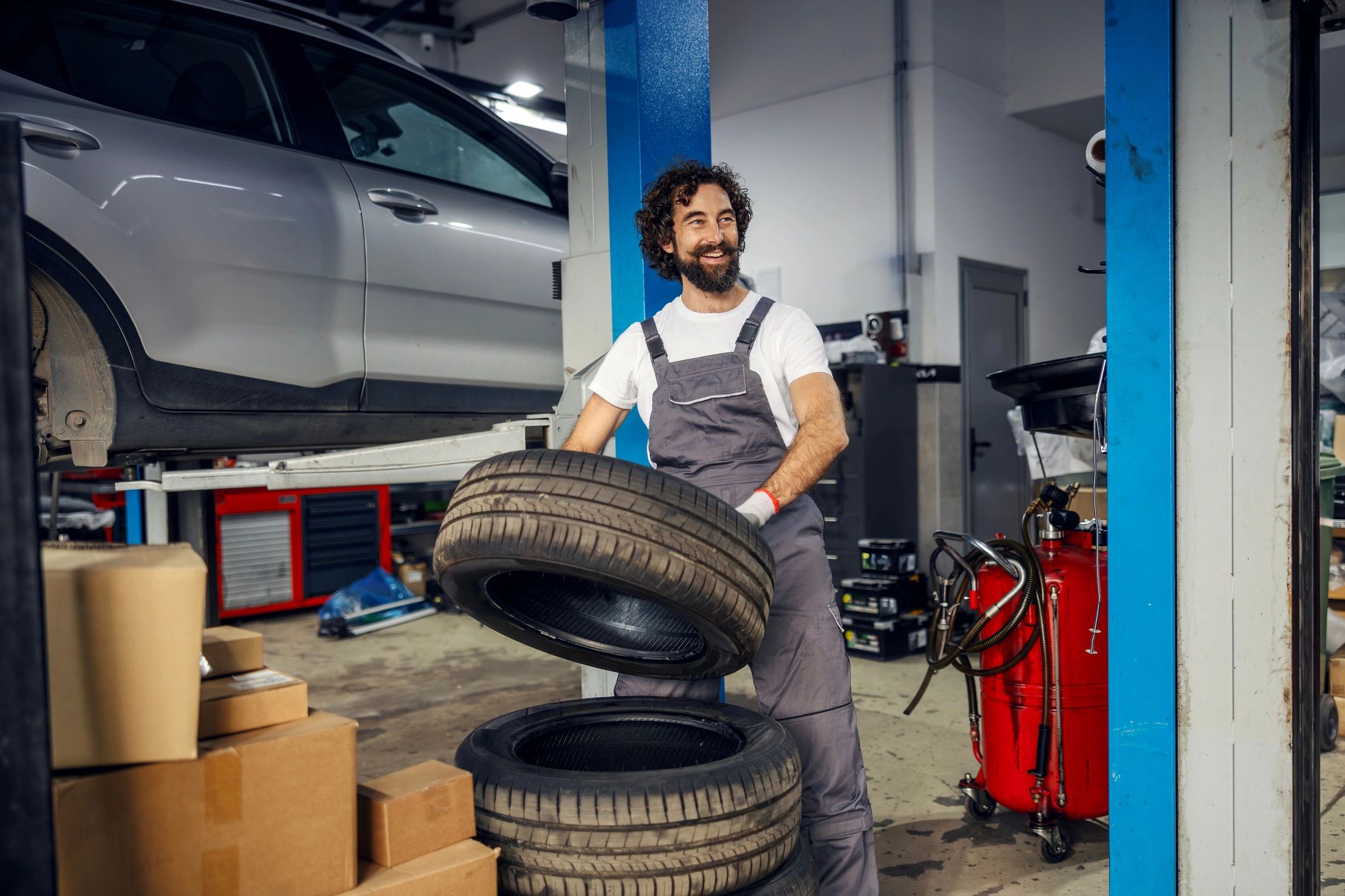 Mécanicien avec pneu dans un atelier automobile