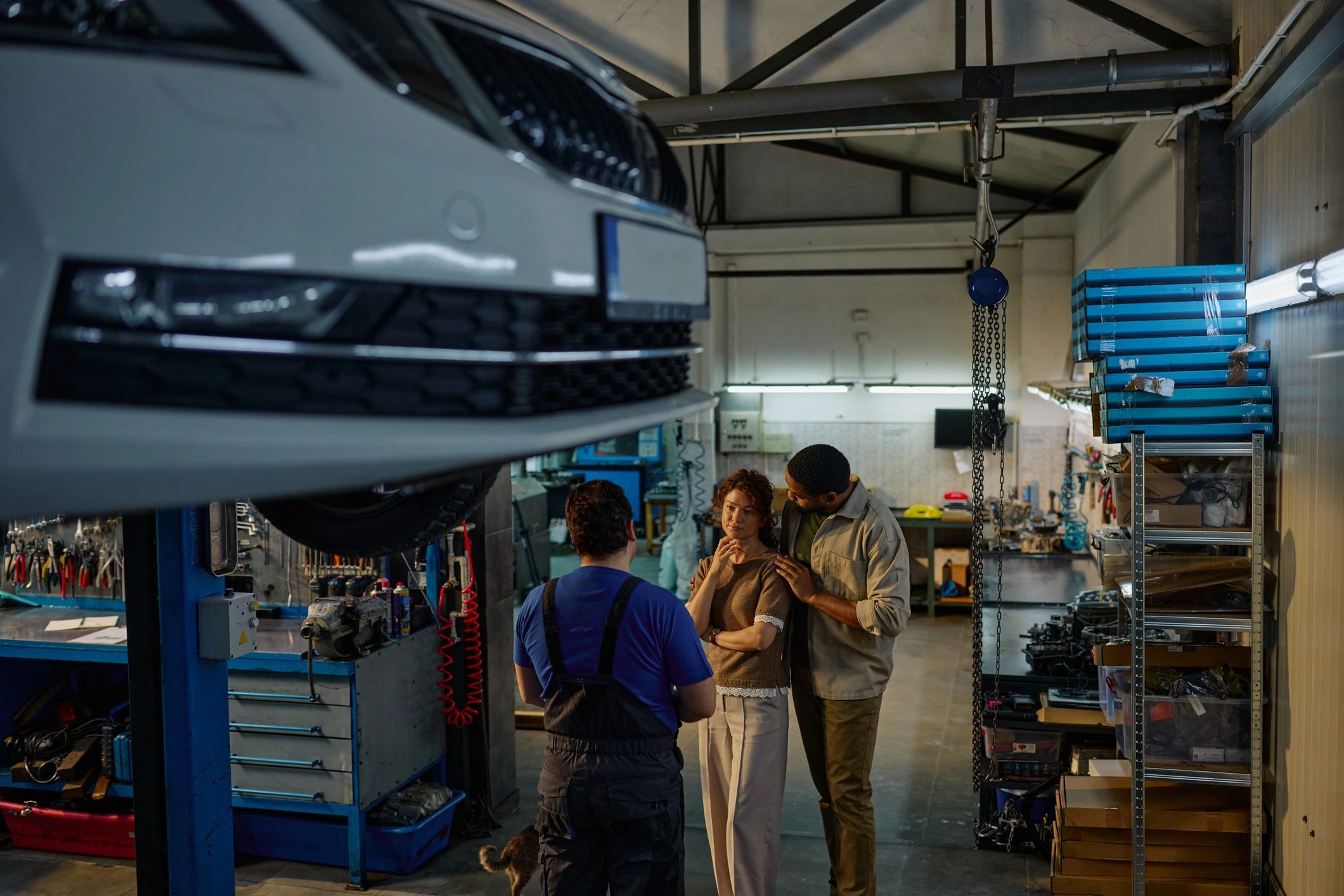 Client discutant avec un mécanicien dans un garage